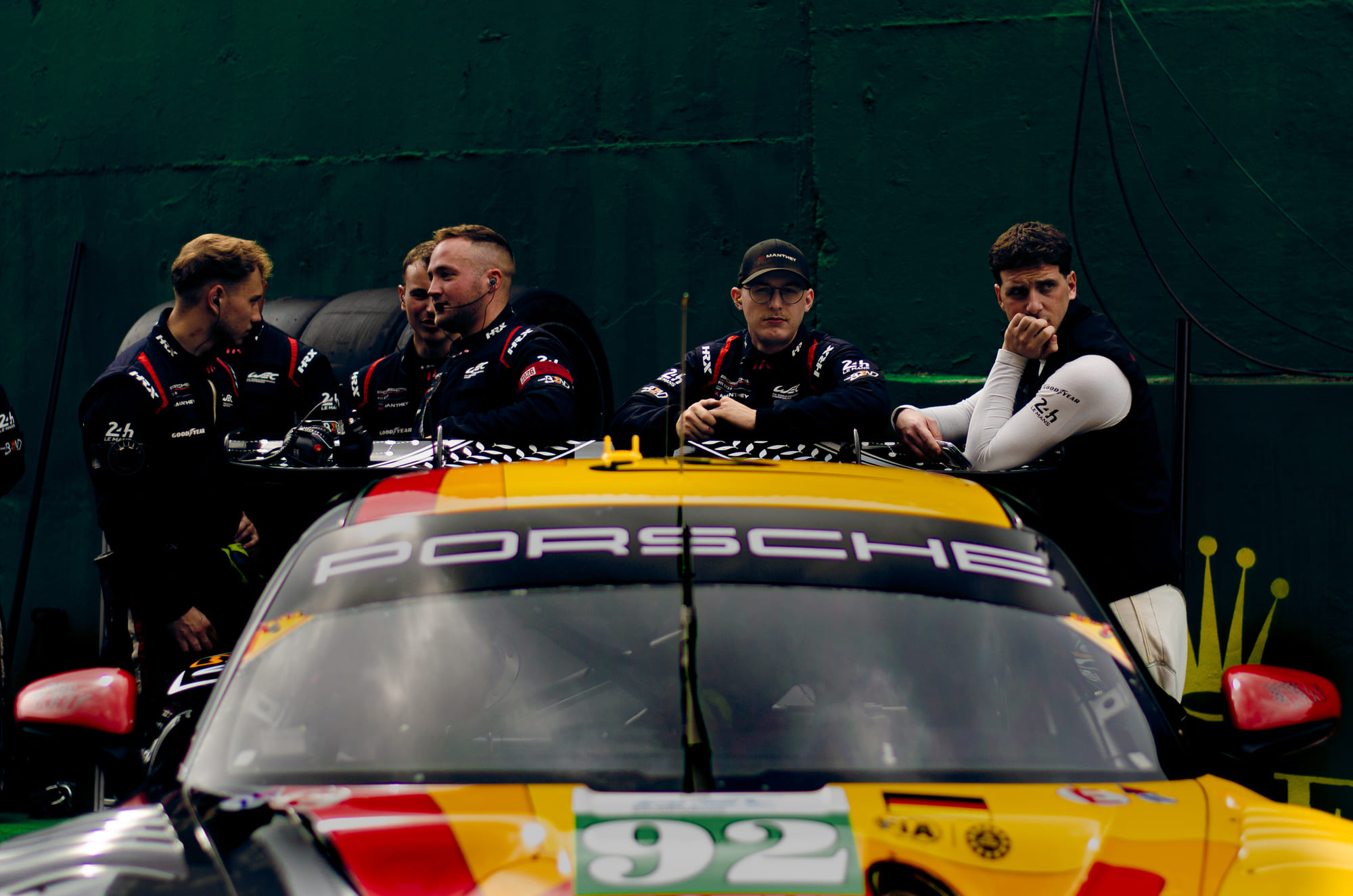 Equipe da The Bend Manthey debruçada sobre o teto do Porsche 911 GT3 R #92, da classe LMGT3, esperando nos boxes durante o grid walk no WEC 6 Horas de São Paulo 2026, em Interlagos